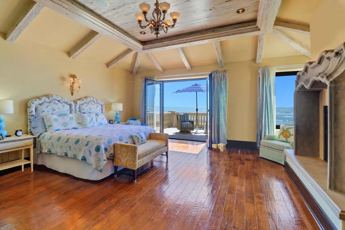 Bedroom with hardwood flooring and vaulted ceiling.