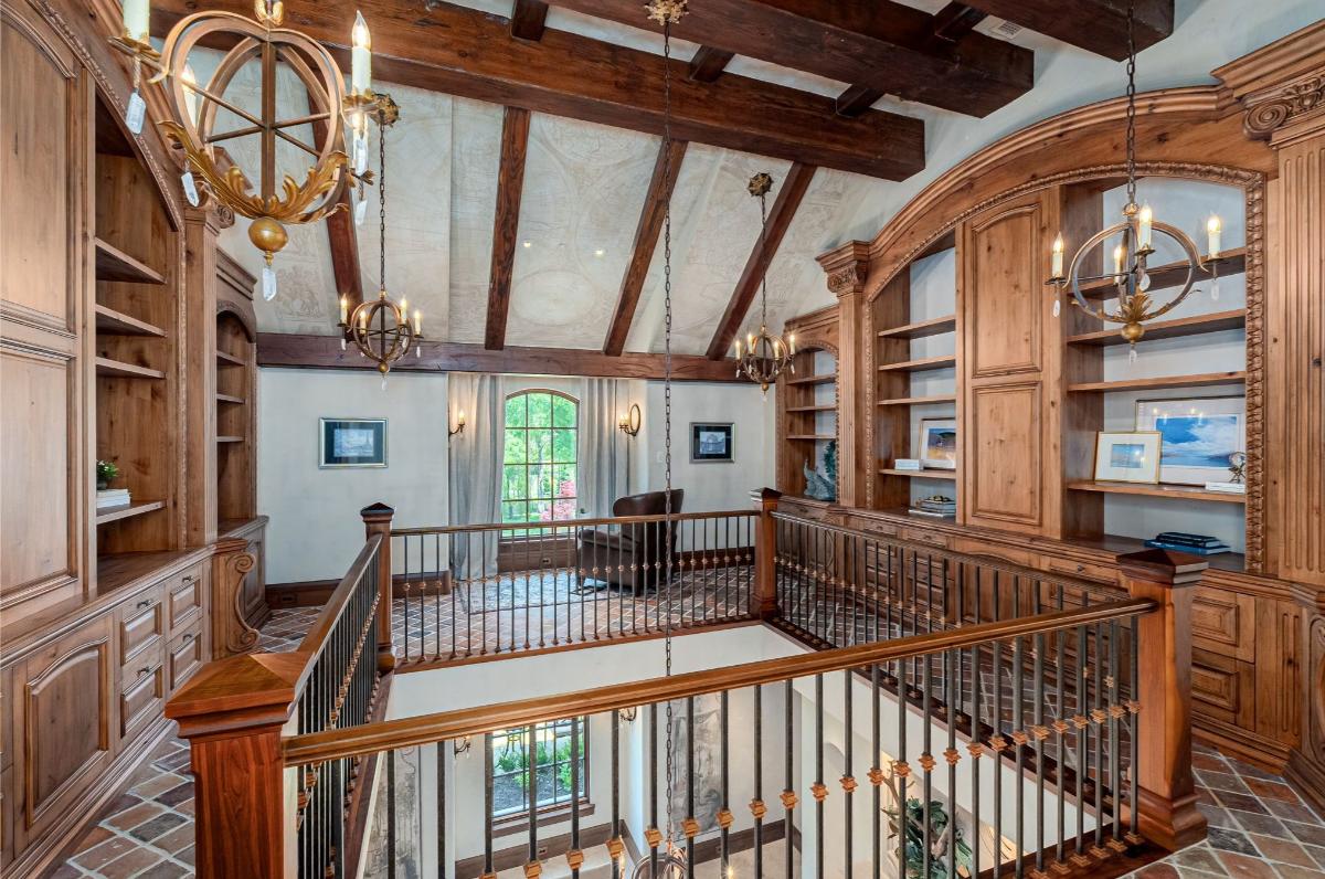 Landing with chandeliers, shelves and vaulted ceiling.