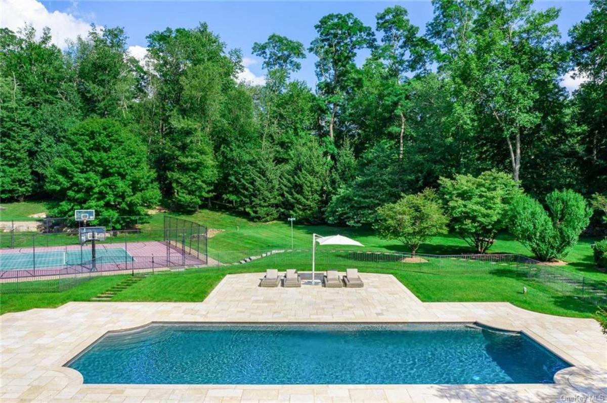 Pool with a basketball court in the background.