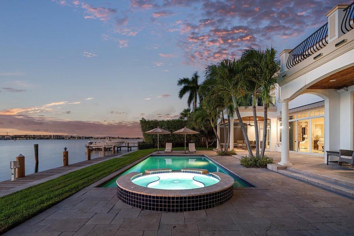 Pool with lounge chairs and a jacuzzi.