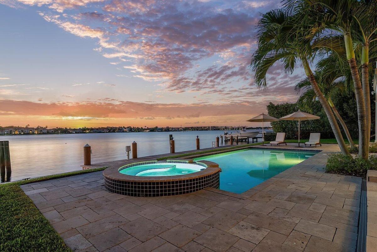 Pool with lounge chairs and a jacuzzi.