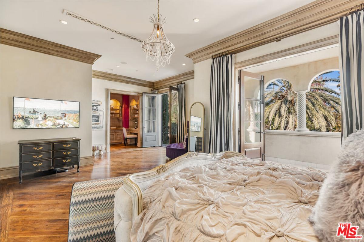 Bedroom with a chandelier and hardwood flooring.
