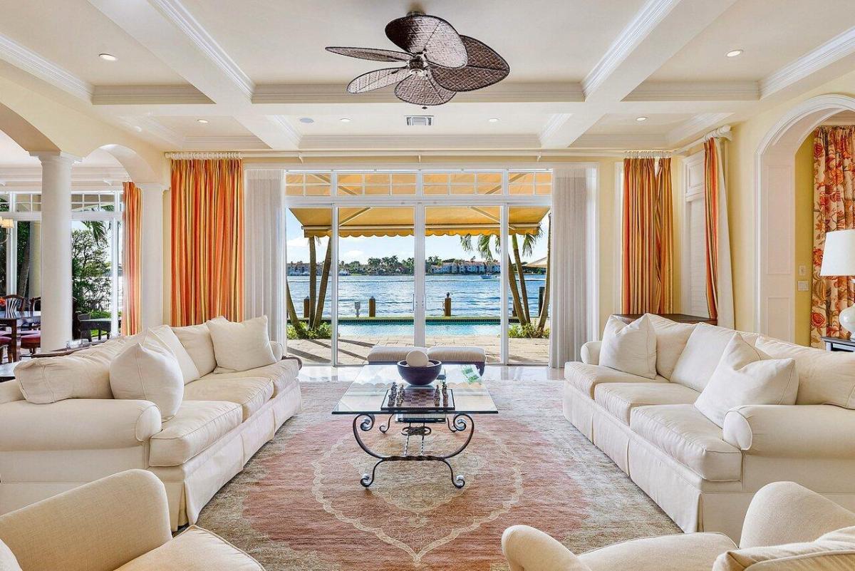 Living room with a large glass door that opens out to the water.