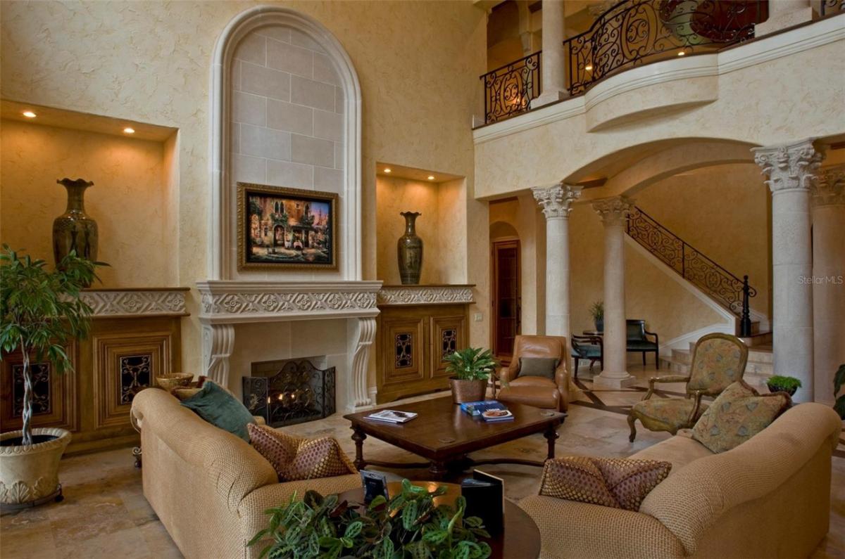 Living room with sofas, custom lighting and a fireplace.