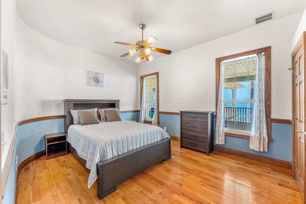 Bedroom with hardwood floor and glass windows.