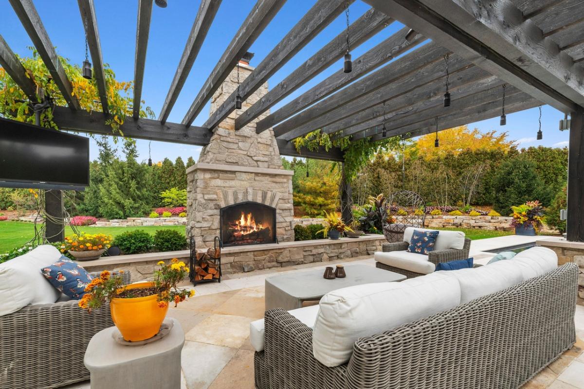 Patio with tables, chairs and a fireplace.