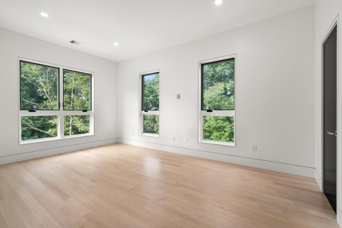 Bedroom with hardwood flooring and glass windows.