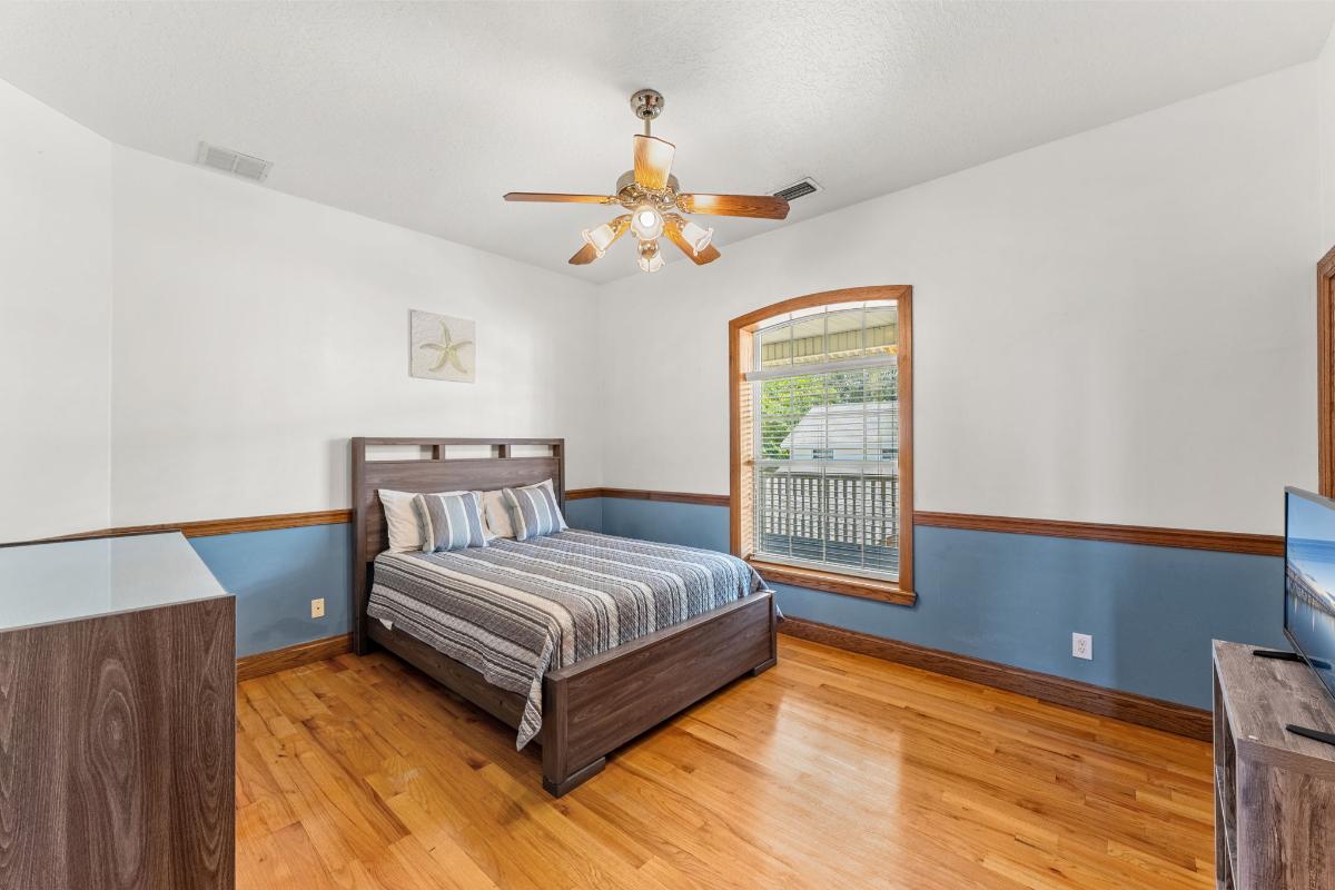 Bedroom with hardwood floor and glass windows.