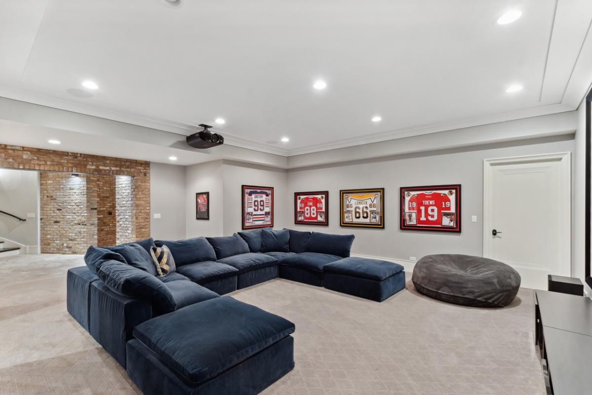 Media room with couches and carpet flooring.