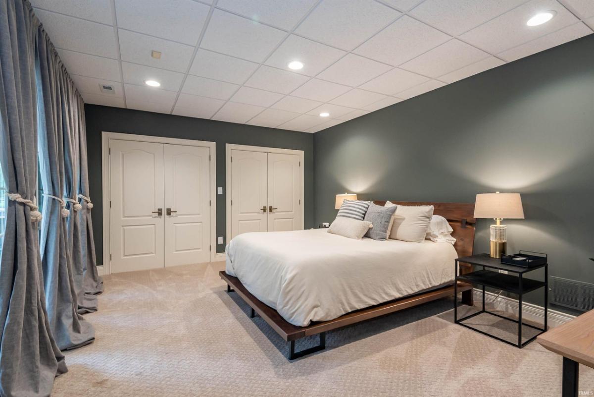 Bedroom with a large bed and carpet flooring.
