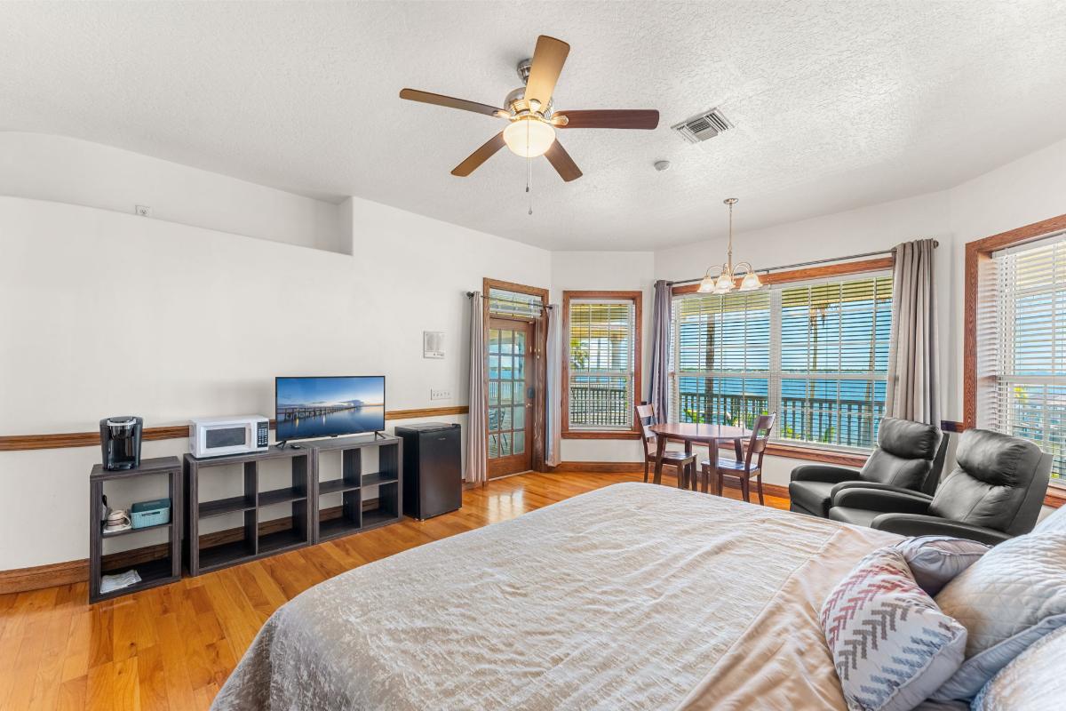 Bedroom with hardwood floor, reclining chairs and glass windows.