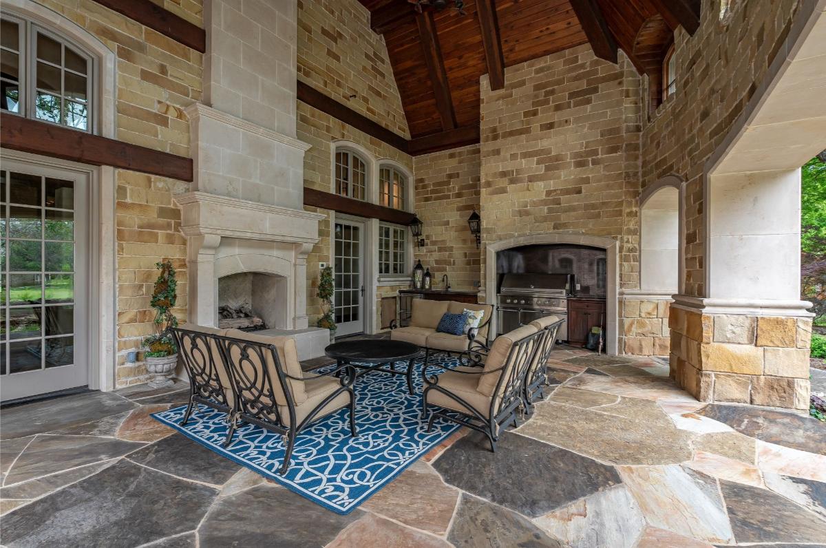 Covered patio with a grill area and a fireplace.