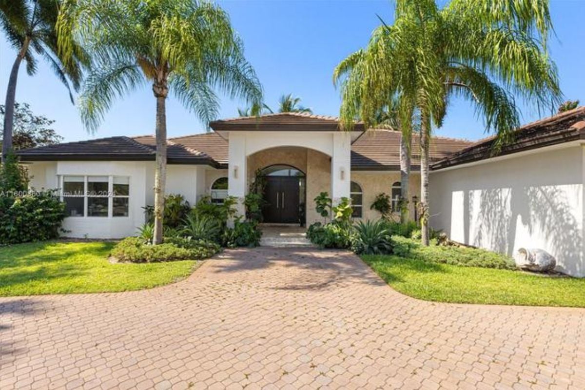A front entry surrounded by plants and trees.
