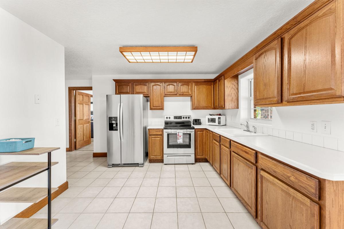 Kitchen with a gas burner, fridge, oven, sink and cabinets.