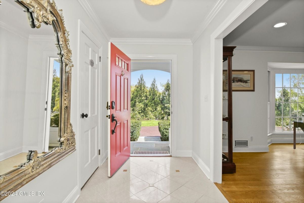 A foyer with a tiled floor and mirror.