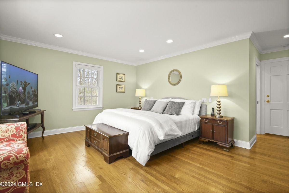 A bedroom furnished with a bed, nightstand, and TV.