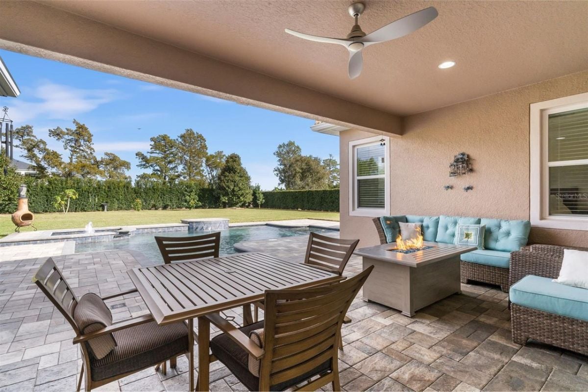 A porch with a table, chairs, firepit, and couch.