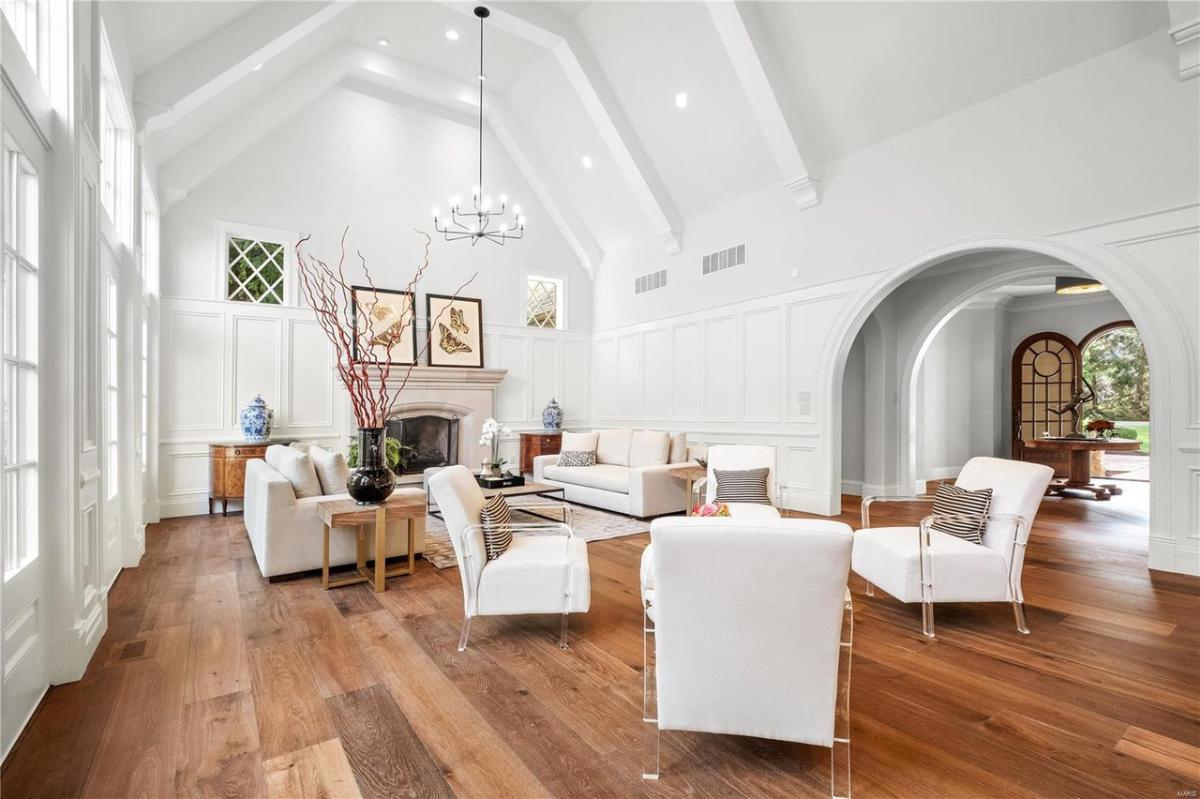 Living room with hardwood floors, high ceilings, and a fireplace.