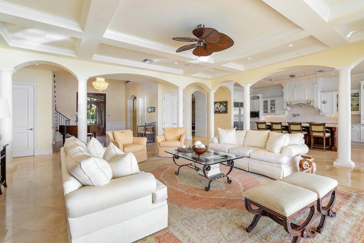 Living room with marble flooring, coffered ceiling and custom lighting.