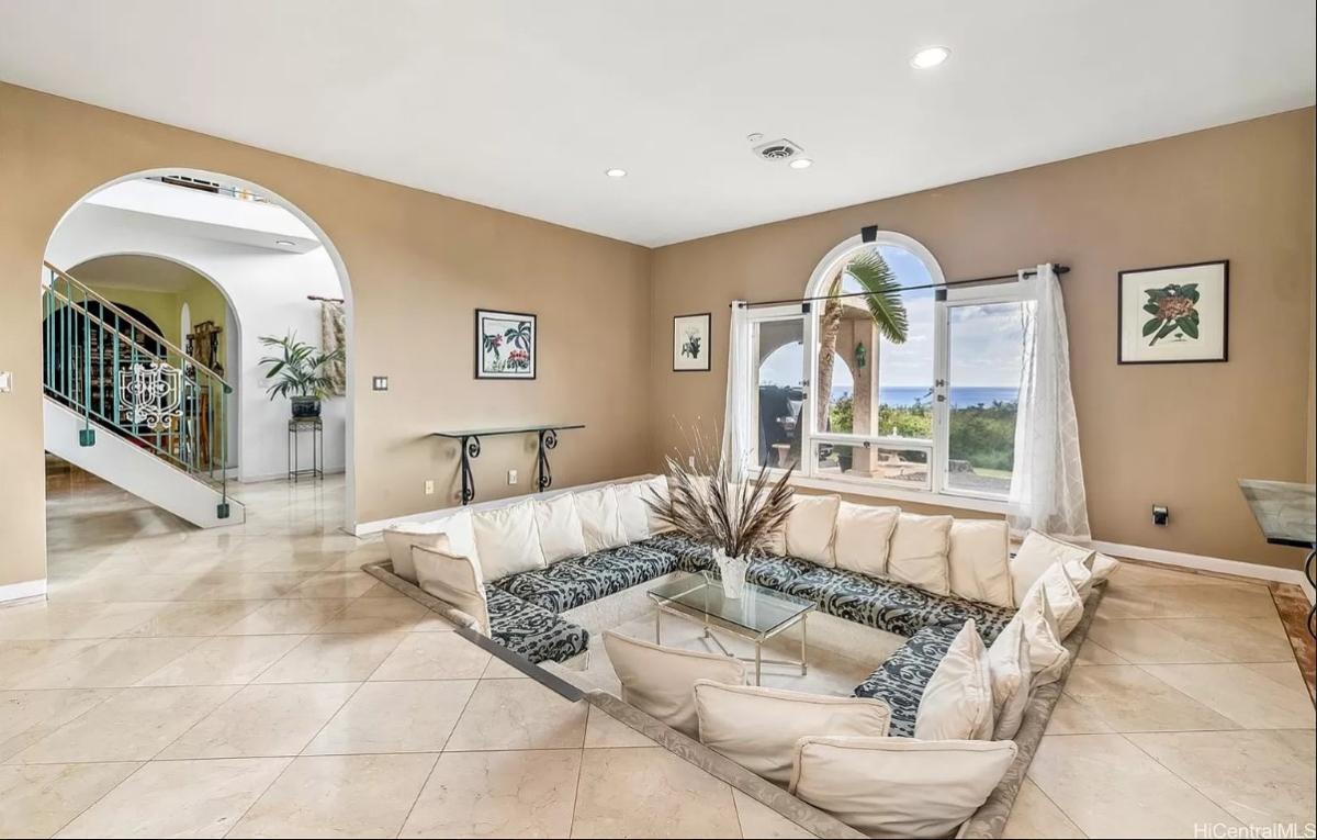 Living room with tile flooring and glass windows.