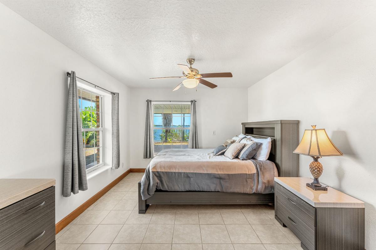 Bedroom with tile flooring and glass windows.