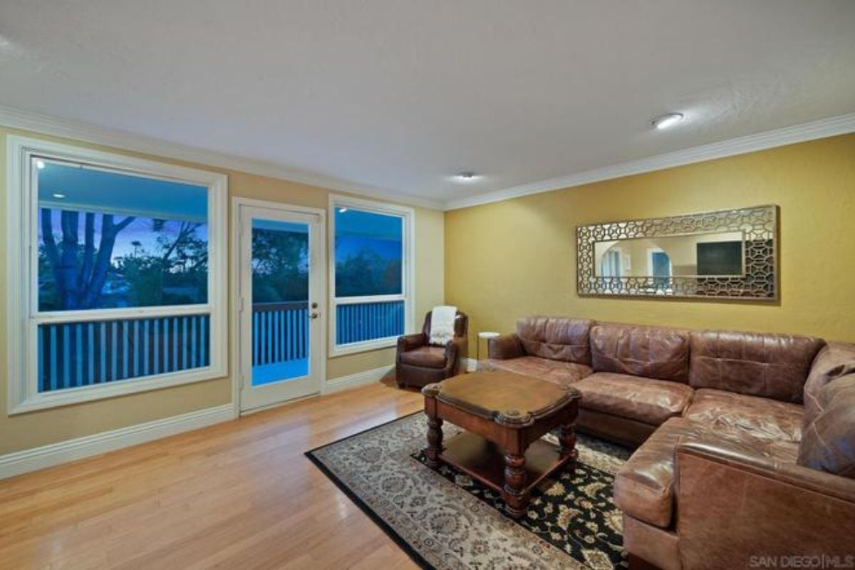 A living room with a coffee table, rug, and brown couches.