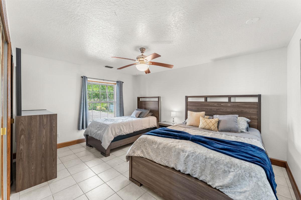 Bedroom with tile flooring and glass windows.