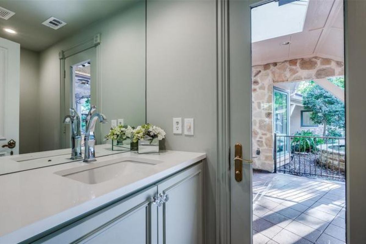A bathroom with a countertop, vanity, and mirror.