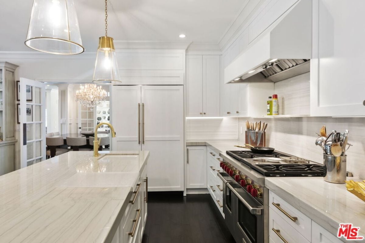 A kitchen with countertops, sink, cabinets, and kitchen appliances.