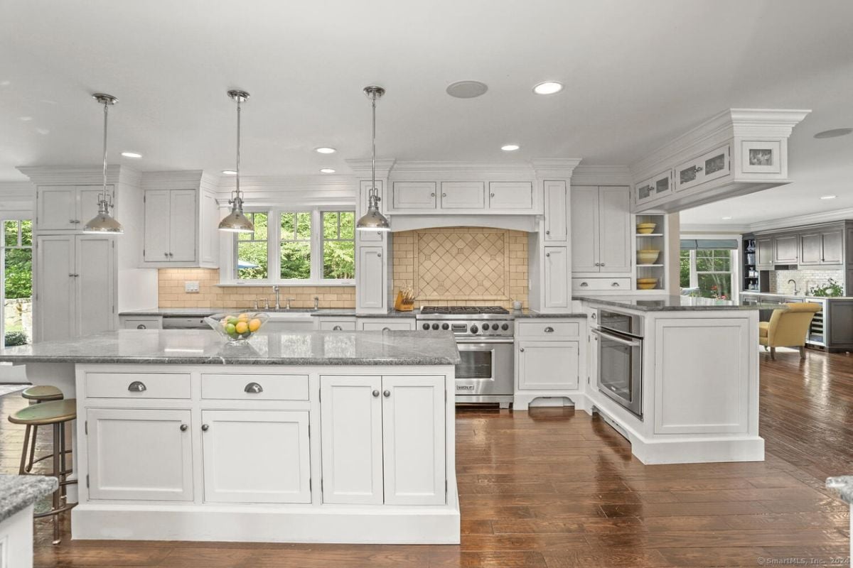 A kitchen with an island, countertops, cabinets, and kitchen appliances.