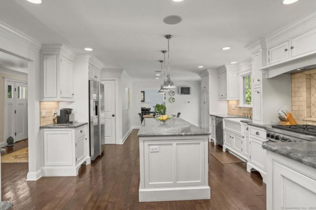 A kitchen with an island, countertops, cabinets, and kitchen appliances.