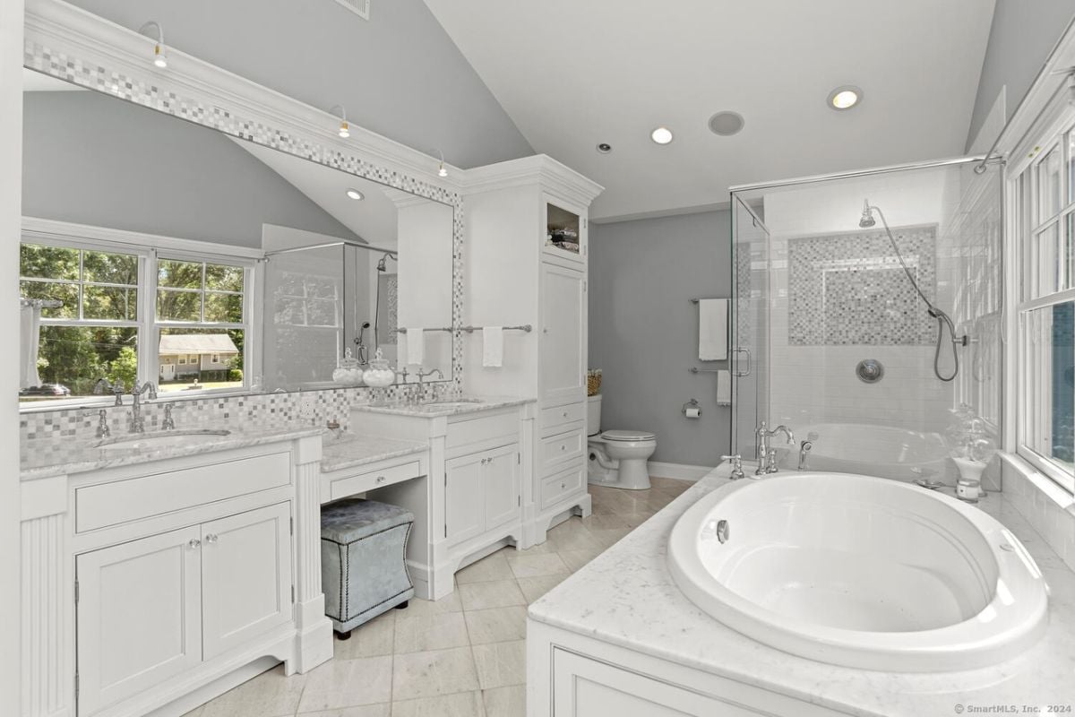 A bathroom with a vanity, mirror, cabinet, toilet, shower room, and bathtub.