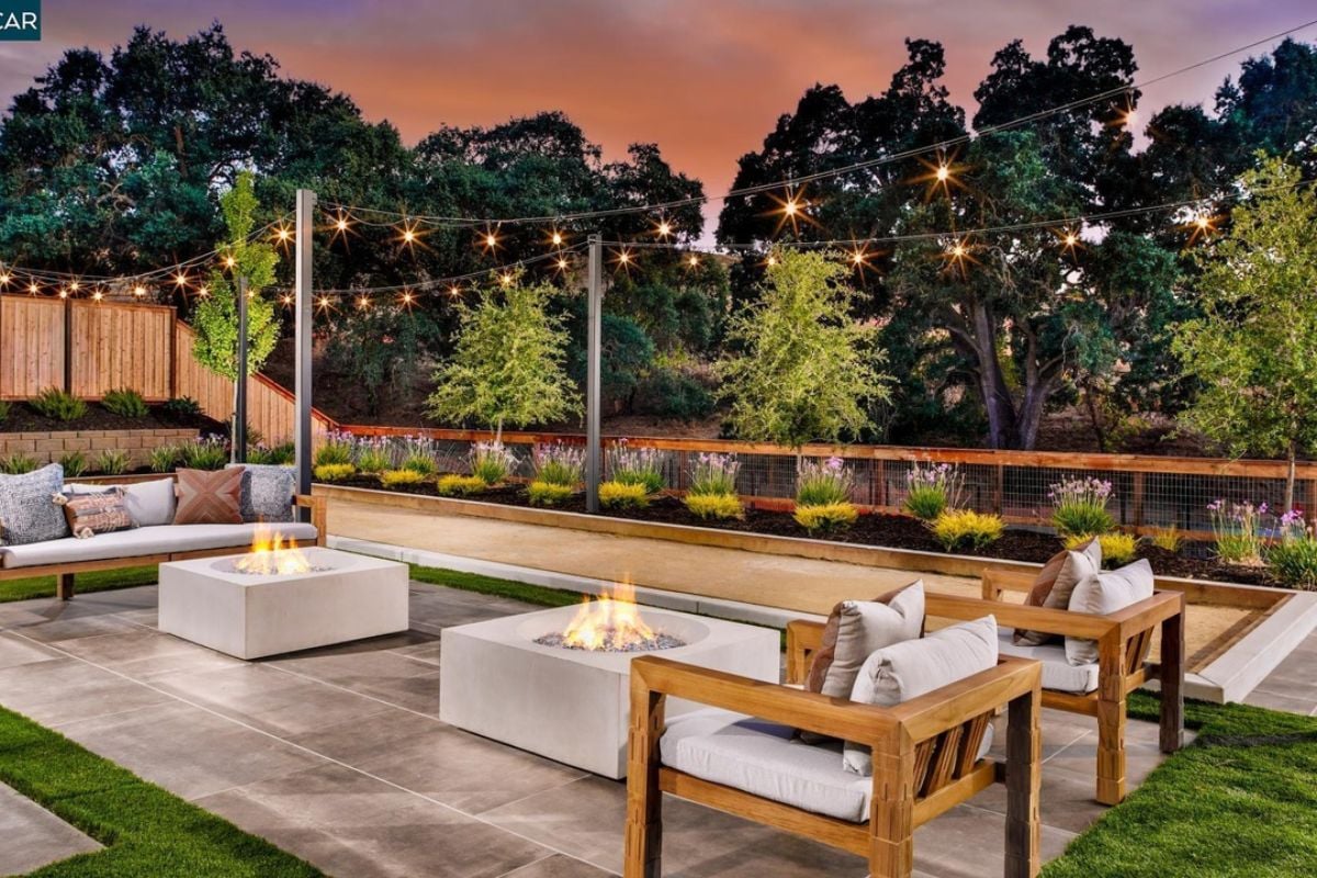 A patio with two fireplaces, a couch, and chairs.