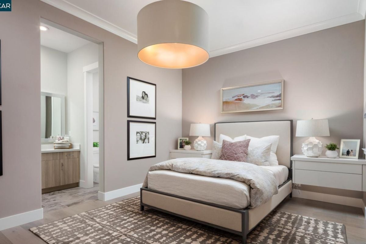A bedroom with a bed, nightstand, painting, and rug.