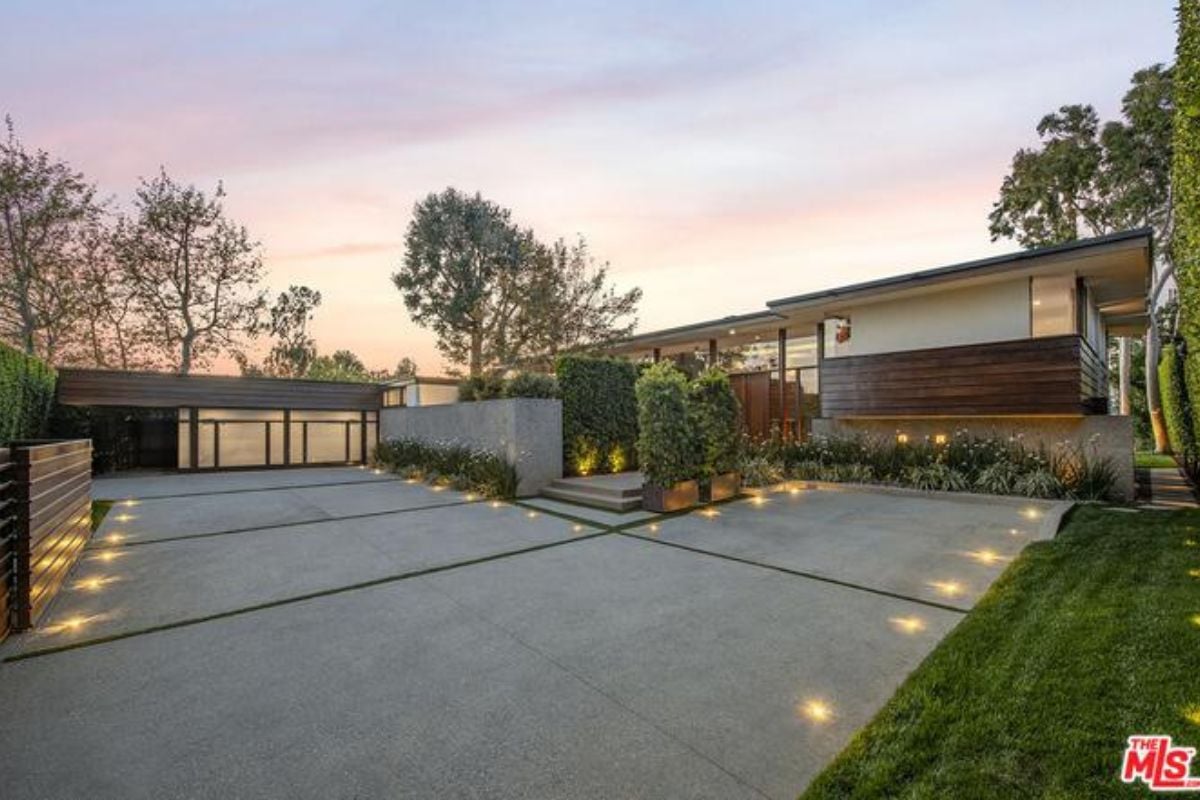 A concrete courtyard surrounded by grass and trees.