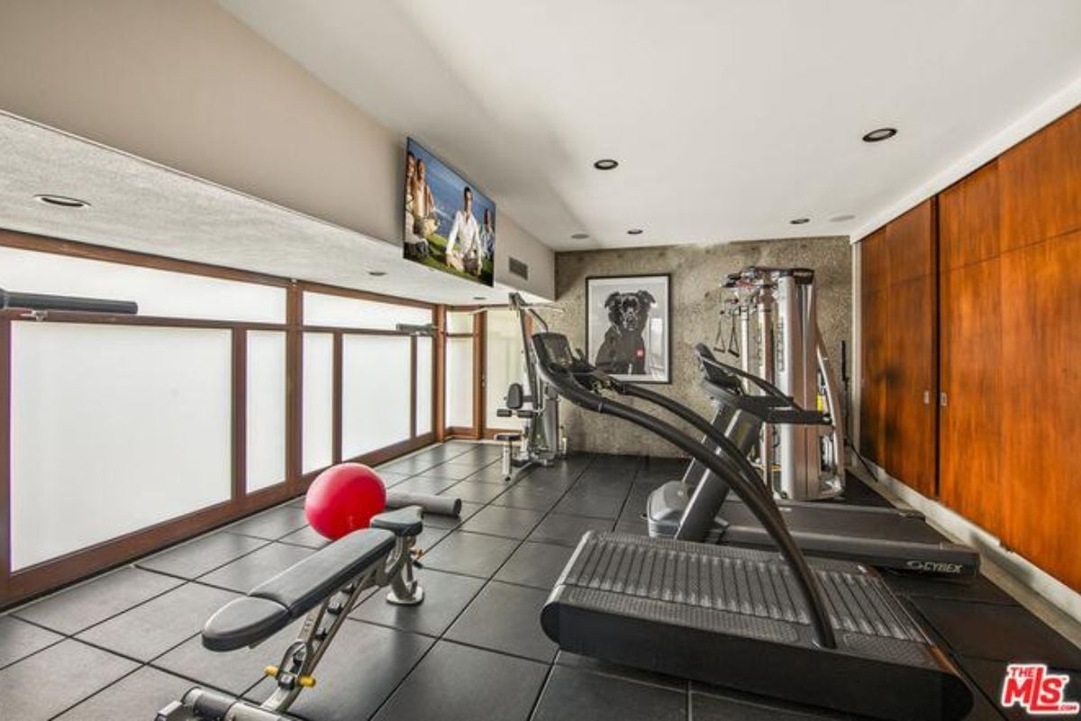 A home gym with a TV and gym equipment.