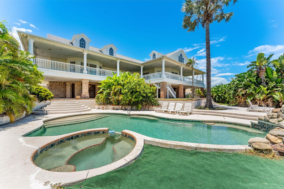 Pool with lounge chairs and a jacuzzi.