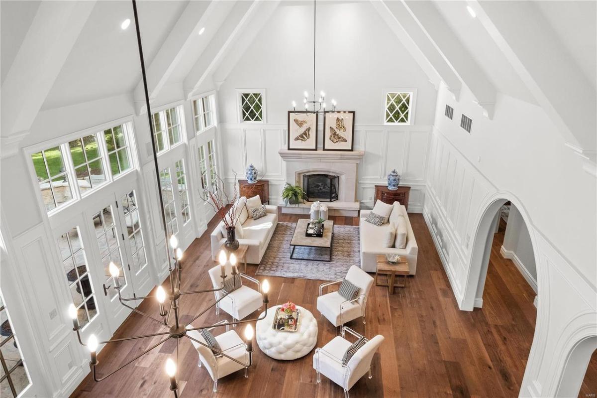 Living room with hardwood floors, high ceilings, and a fireplace.