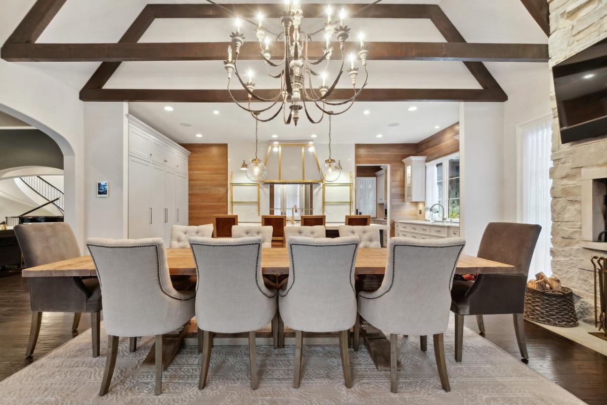 Dining room with a wood table, chairs and a chandelier.