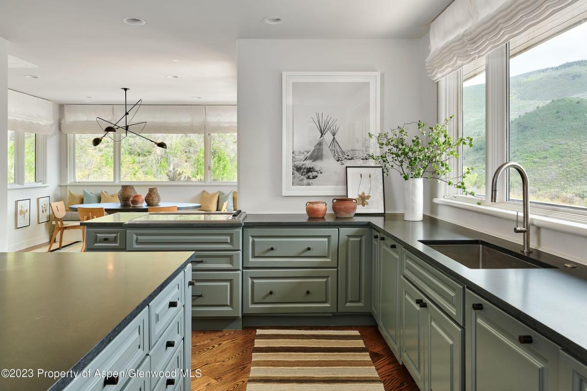 Kitchen with a large island glass windows and custom cabinetry.