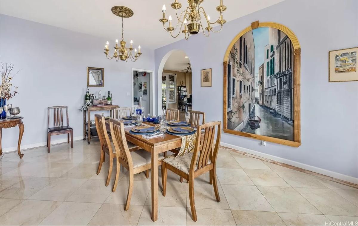 Dining room with wood table, chairs and chandeliers.