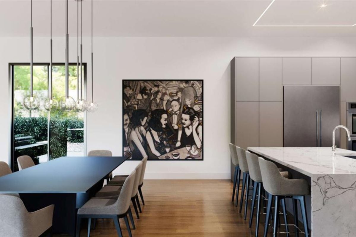 A dining area and kitchen with a painting, a dining table surrounded by chairs, countertops, and a sink.