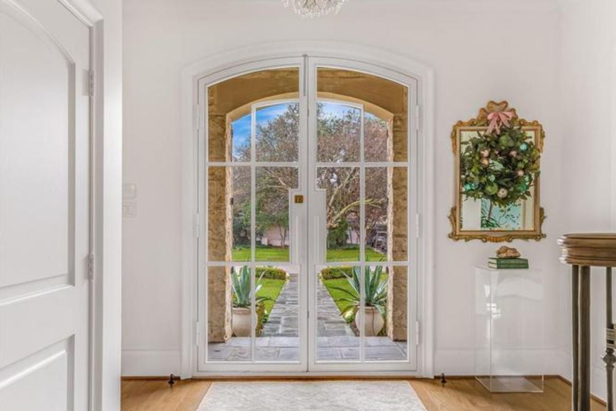 A foyer with a wooden floor, rug, and painting.