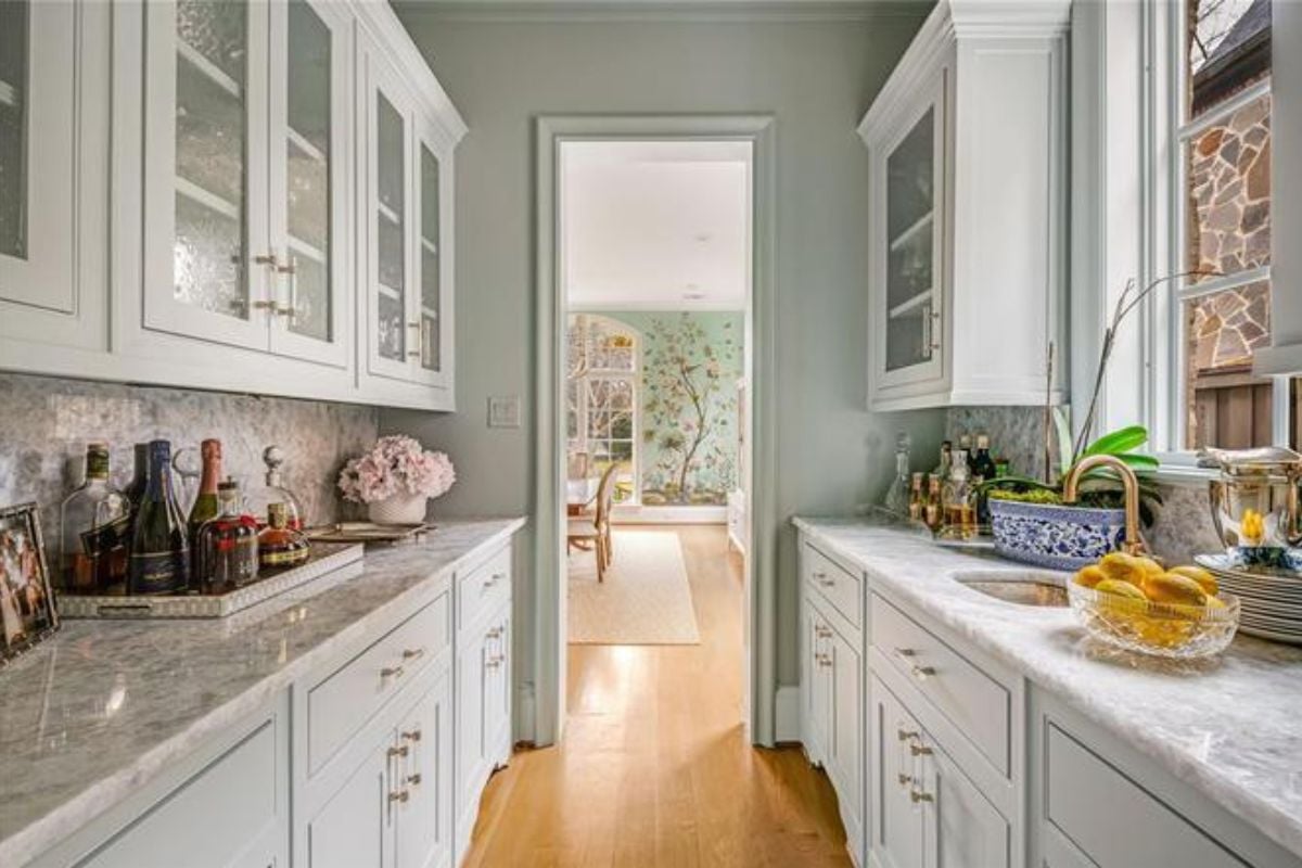 A narrow kitchen with countertops and cabinets.