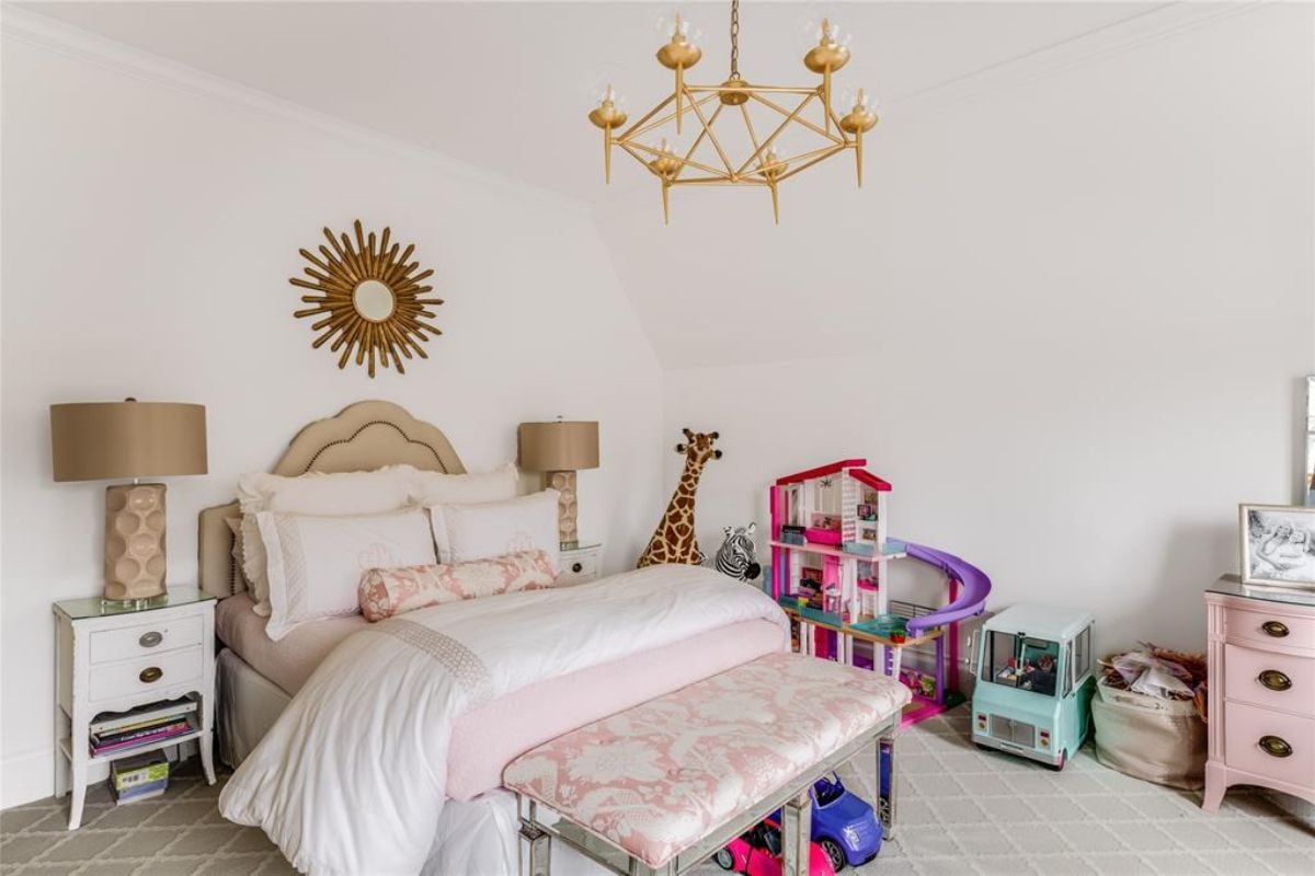 A kid's bedroom with a nightstand, chandelier, and toys.