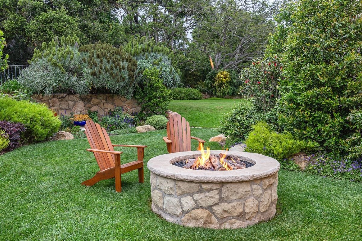 There is a patio with a fire pit and chairs.