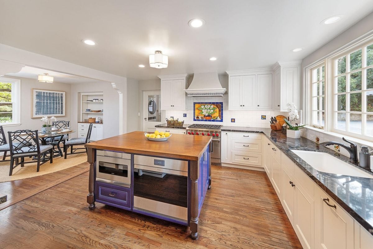 A kitchen with a center island, cabinets, countertop, sink, and kitchen appliances.