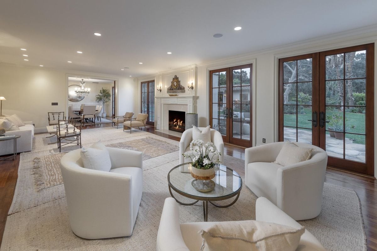 A living room with a fireplace, white couch, chairs, and coffee table.