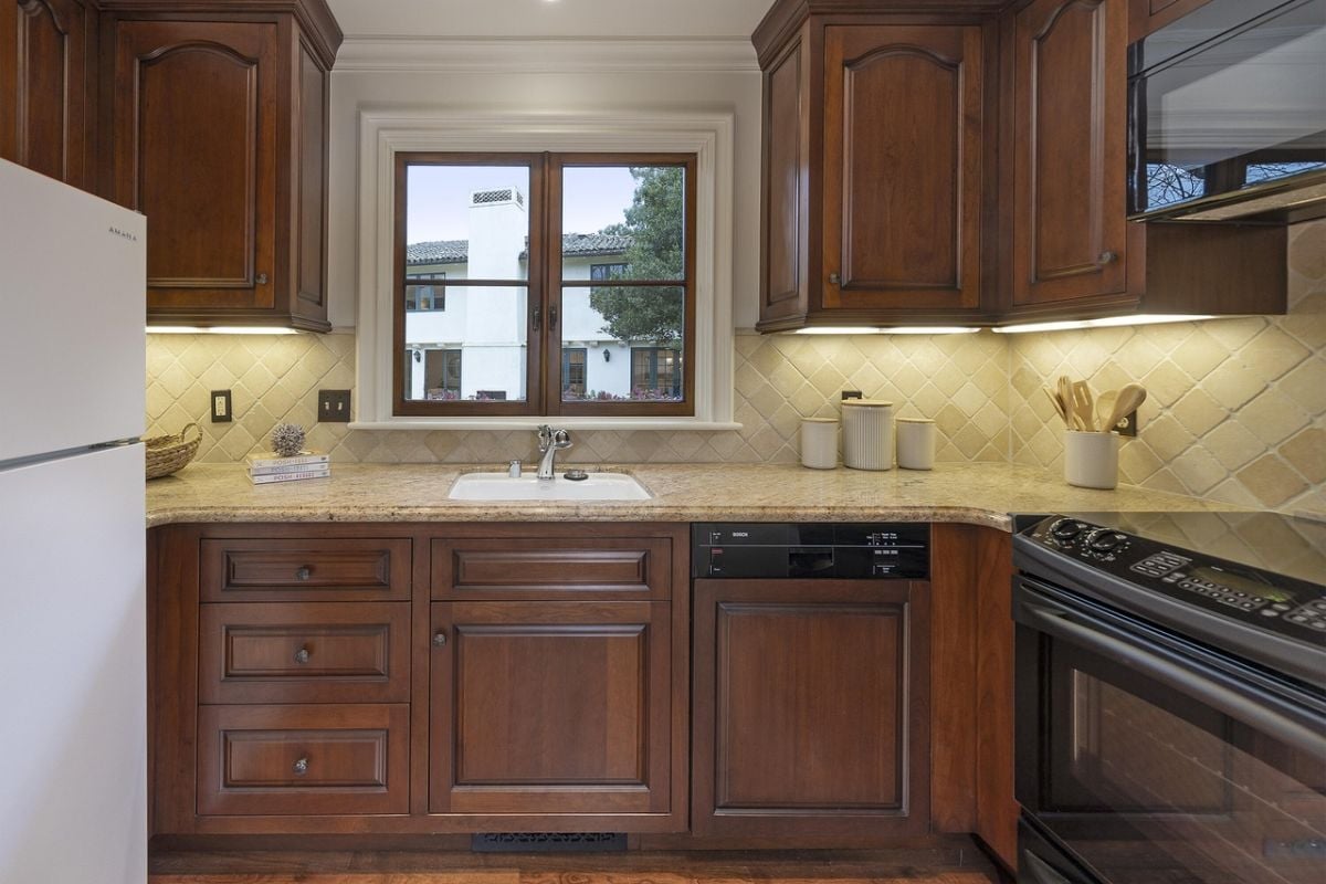 A kitchen with countertop, cabinets, and sink.