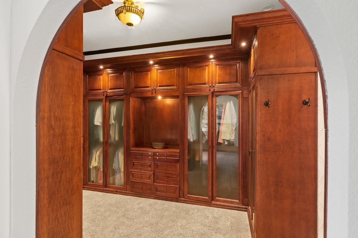 A walk-in closet with cabinets and drawers.